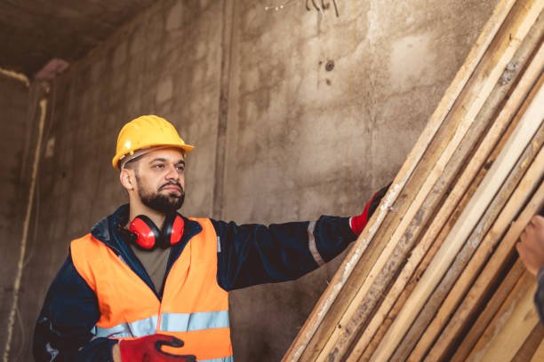 Two construction workers carrying a scaffolding at a building site - people at work concepts